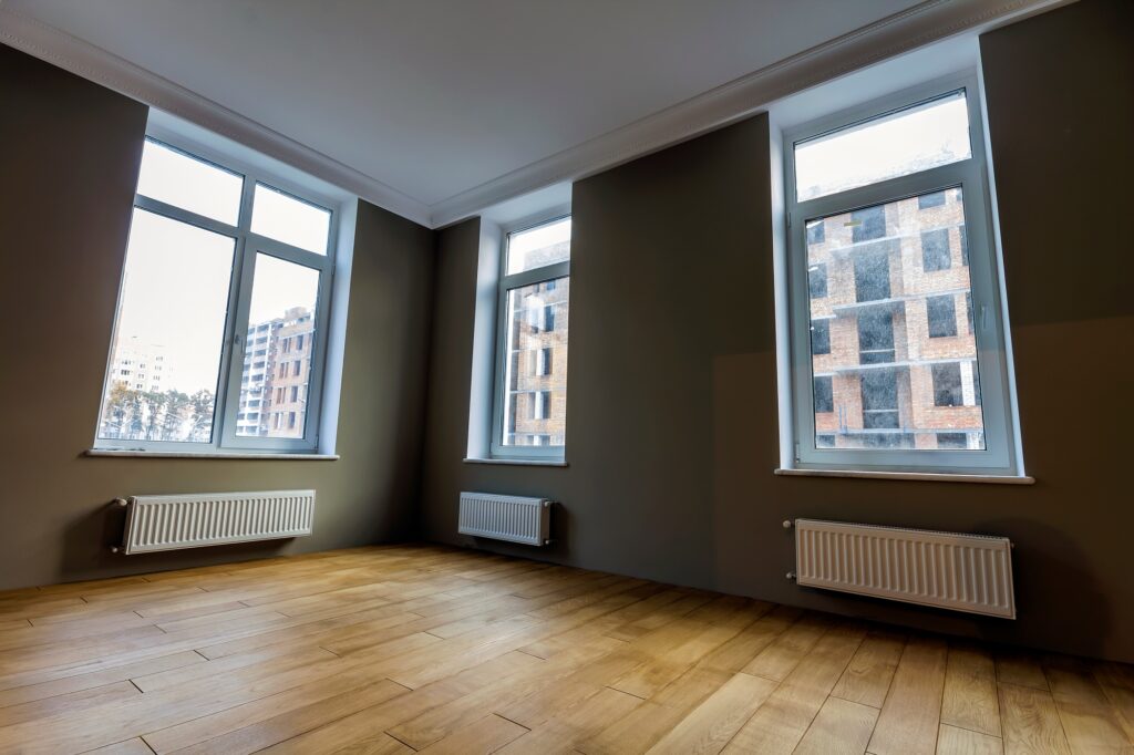 New renovated room interior with big windows, heating radiators